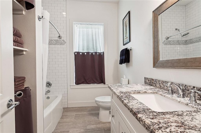 full bathroom featuring vanity, tiled shower / bath combo, and toilet