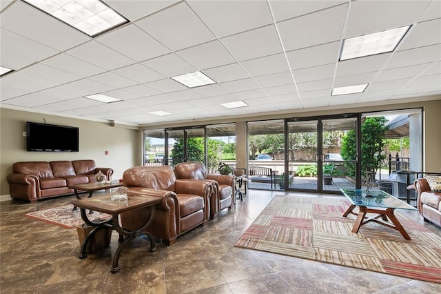 living room featuring tile floors and a paneled ceiling