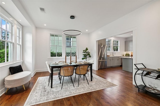 dining space with plenty of natural light, sink, and dark hardwood / wood-style flooring