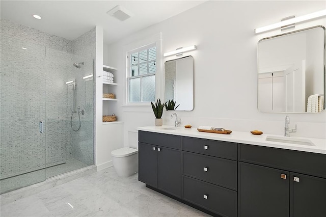 bathroom featuring tile flooring, toilet, dual vanity, and a shower with shower door