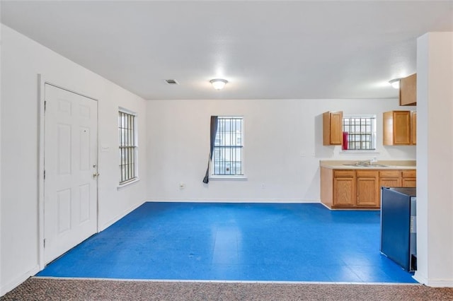 interior space with a wealth of natural light, tile floors, and sink