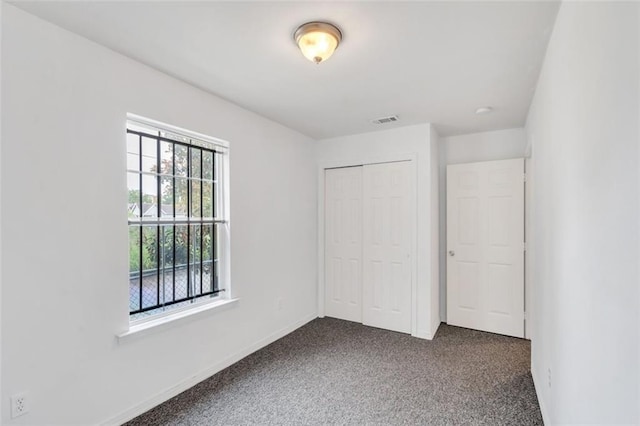 spare room featuring dark colored carpet