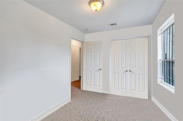 unfurnished bedroom with a closet and carpet floors