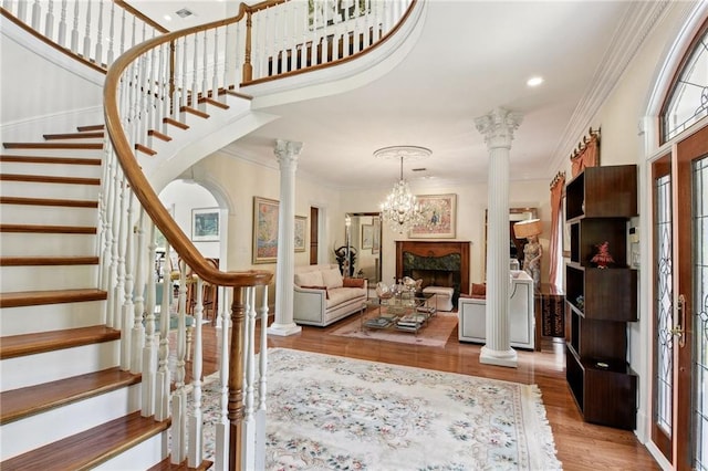 foyer with ornamental molding, light hardwood / wood-style flooring, and ornate columns