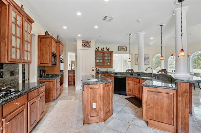 kitchen with black appliances, pendant lighting, dark stone countertops, and a kitchen island with sink