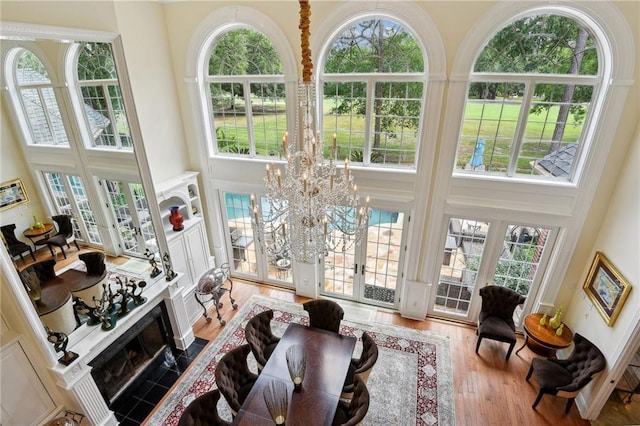 living room with a high ceiling, a fireplace, french doors, and a chandelier