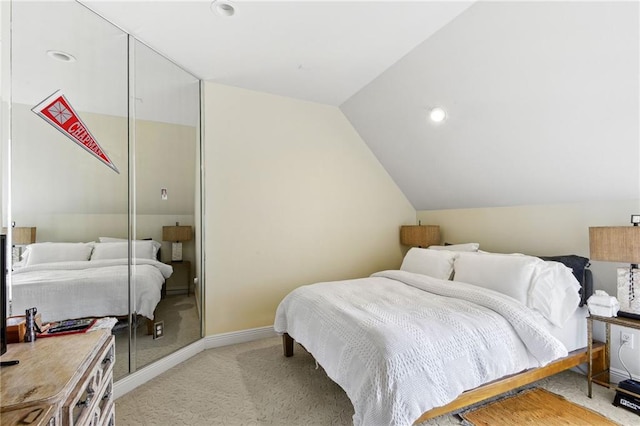 bedroom with vaulted ceiling and light colored carpet