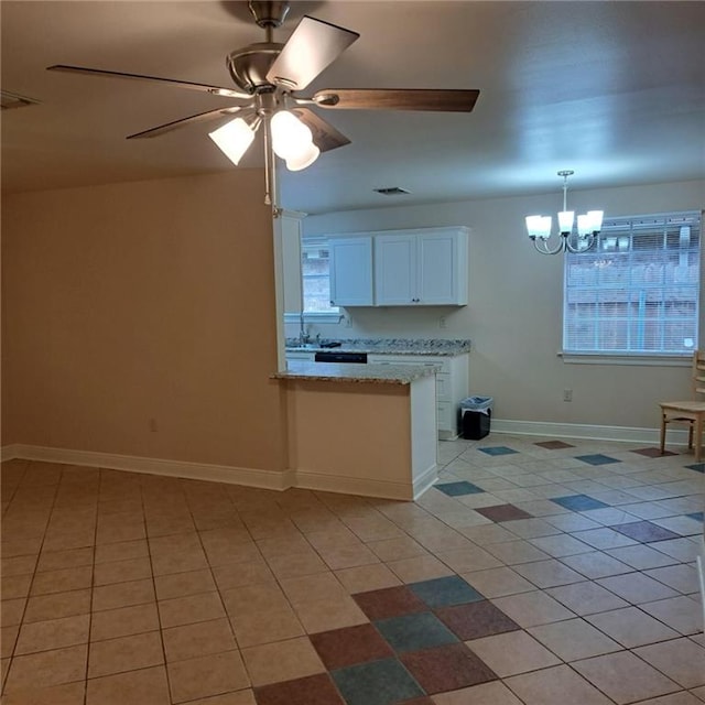 kitchen featuring light stone countertops, decorative light fixtures, light tile flooring, ceiling fan with notable chandelier, and white cabinetry