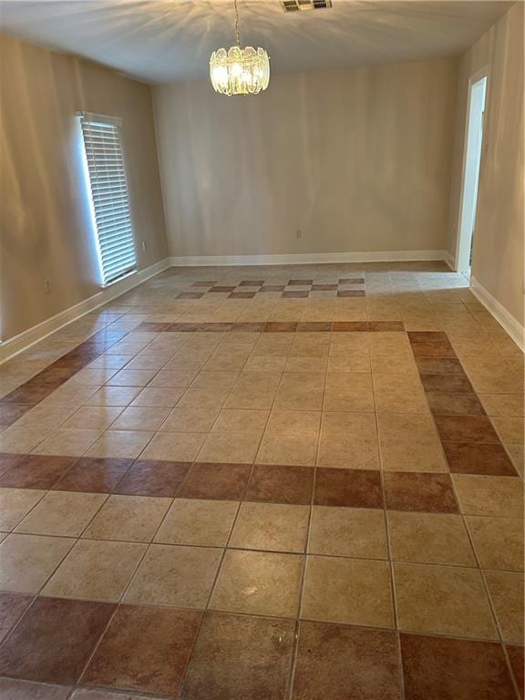 unfurnished room featuring tile floors and an inviting chandelier