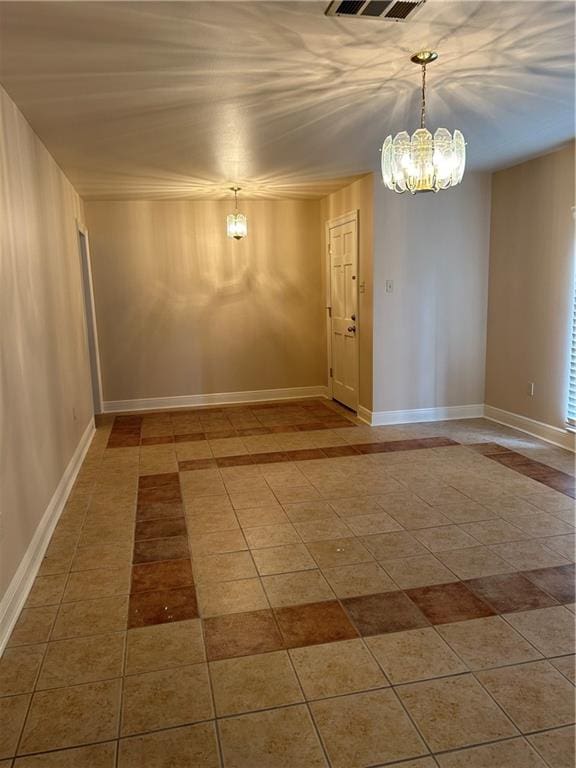 tiled empty room with an inviting chandelier