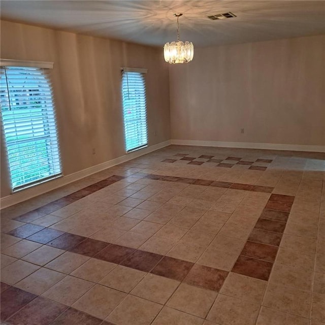 tiled empty room featuring a notable chandelier