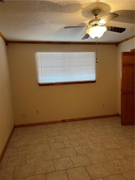 unfurnished room featuring a textured ceiling, ornamental molding, ceiling fan, and tile floors