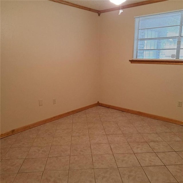 spare room with tile floors and crown molding