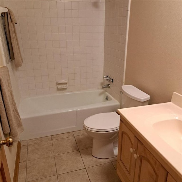 full bathroom with tile flooring, tiled shower / bath combo, vanity, and toilet