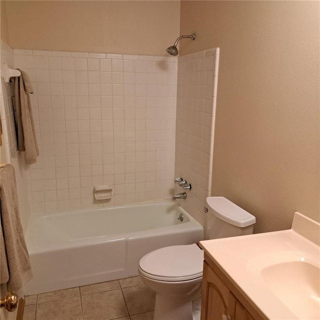 full bathroom with tile floors, toilet, tiled shower / bath combo, and vanity