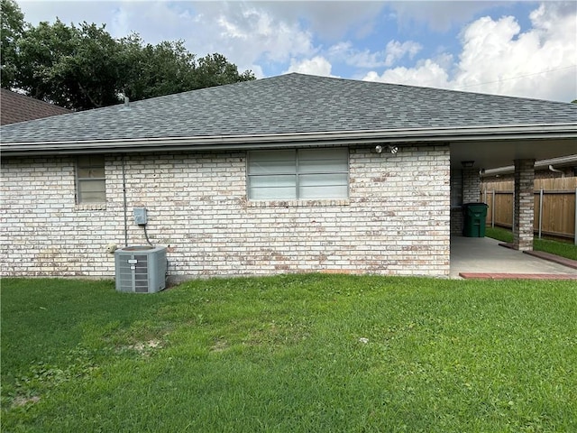 rear view of house featuring a yard, a patio, and central air condition unit