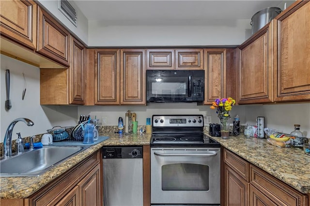 kitchen featuring stainless steel appliances, sink, and light stone counters