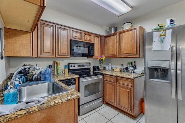 kitchen featuring sink, stainless steel appliances, light tile flooring, and light stone counters