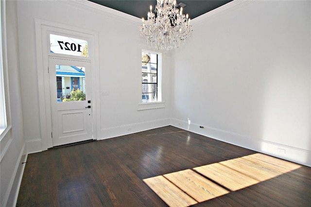 foyer featuring crown molding, dark wood-type flooring, and a notable chandelier