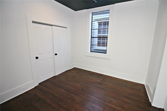 unfurnished bedroom featuring a closet, crown molding, and hardwood / wood-style flooring