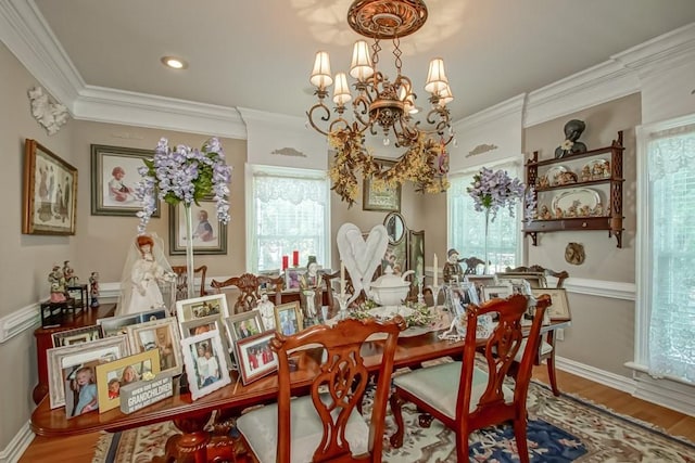 dining space featuring ornamental molding, wood-type flooring, a chandelier, and a wealth of natural light