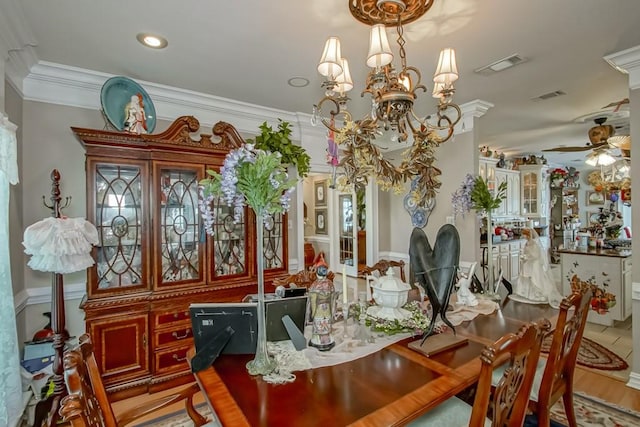 dining space with ceiling fan with notable chandelier and crown molding