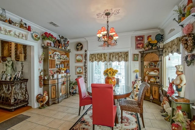 dining area with an inviting chandelier, crown molding, and light tile floors