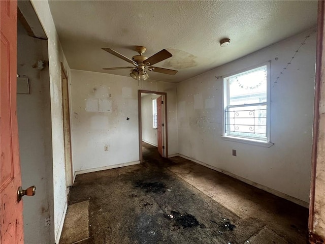 interior space featuring ceiling fan and a textured ceiling