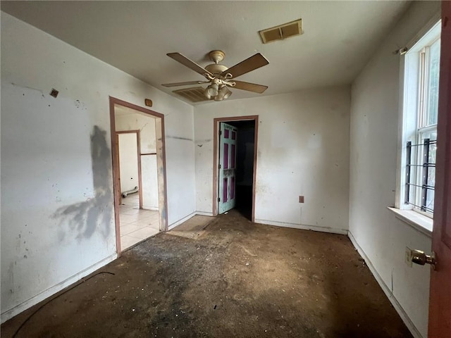 unfurnished bedroom featuring concrete flooring, ceiling fan, and multiple windows