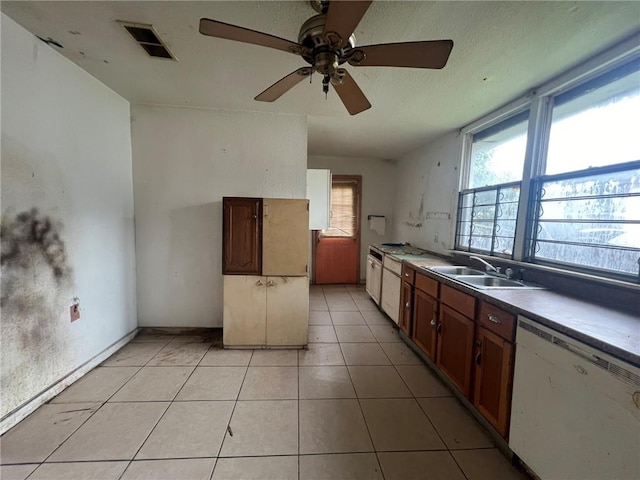 kitchen featuring ceiling fan, light tile floors, sink, dishwasher, and plenty of natural light