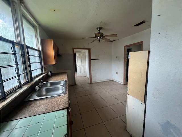 kitchen with sink, ceiling fan, and light tile floors