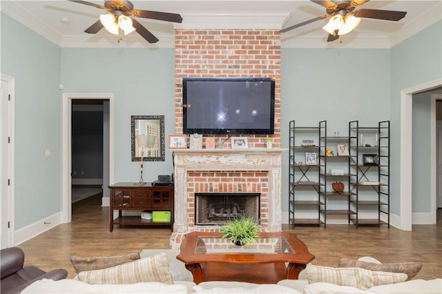 living room with ceiling fan, a fireplace, hardwood / wood-style flooring, and brick wall