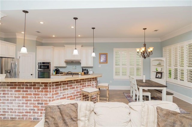 kitchen with plenty of natural light, dark hardwood / wood-style floors, pendant lighting, and stainless steel appliances