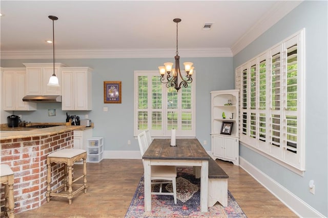 dining space featuring plenty of natural light, an inviting chandelier, crown molding, and wood-type flooring