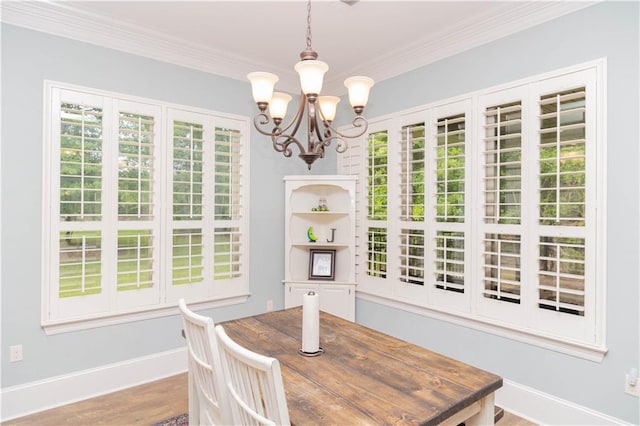 dining room with a notable chandelier, hardwood / wood-style floors, and ornamental molding