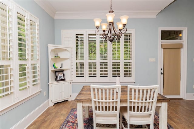 dining space featuring a notable chandelier, a wealth of natural light, ornamental molding, and hardwood / wood-style floors