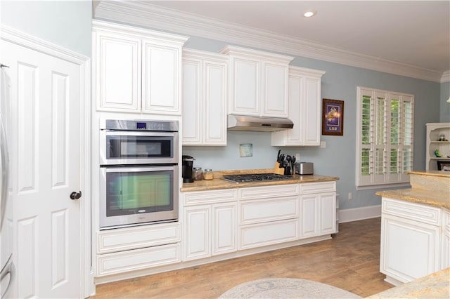 kitchen featuring appliances with stainless steel finishes, light hardwood / wood-style floors, light stone countertops, and crown molding