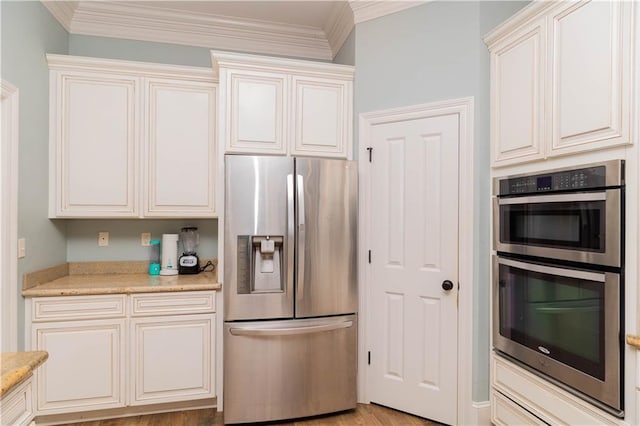 kitchen with ornamental molding, light hardwood / wood-style floors, light stone counters, and appliances with stainless steel finishes