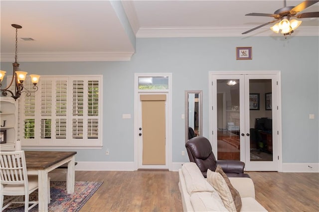 interior space featuring crown molding, ceiling fan with notable chandelier, french doors, and hardwood / wood-style floors