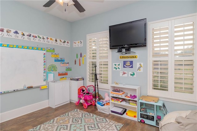 playroom featuring plenty of natural light, ceiling fan, and dark hardwood / wood-style flooring