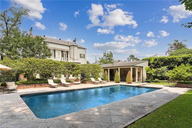 view of pool with a patio area and a diving board