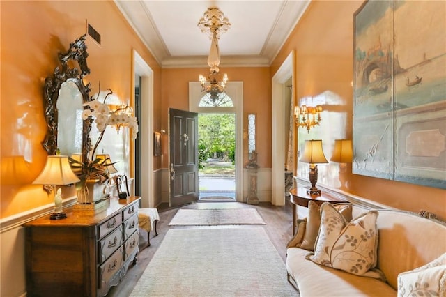 foyer entrance with an inviting chandelier and ornamental molding