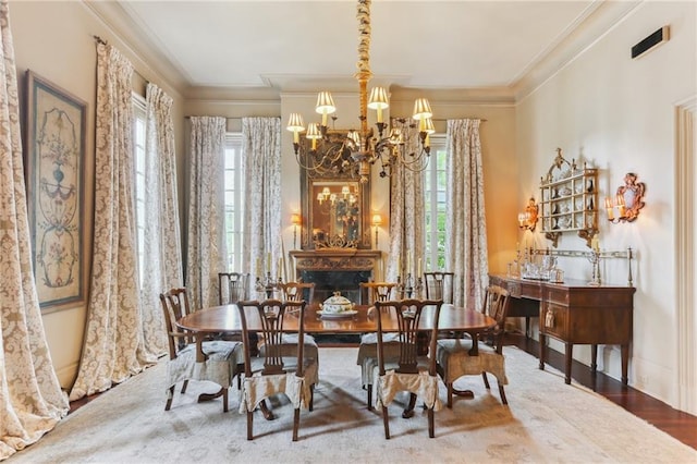 dining area featuring crown molding, a premium fireplace, hardwood / wood-style floors, and a chandelier