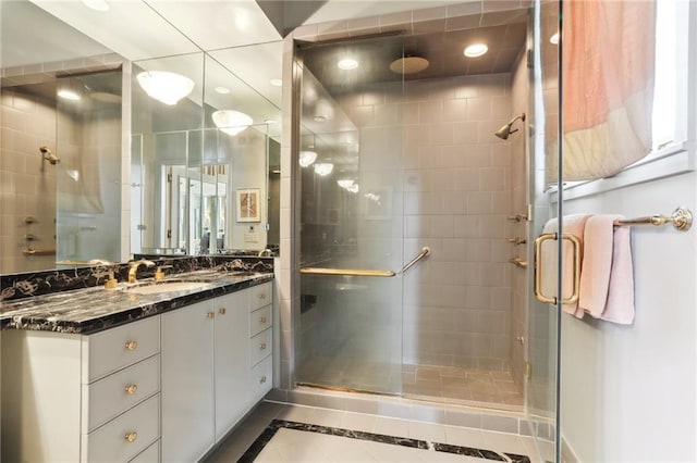 bathroom featuring tile patterned flooring, a shower with door, and vanity