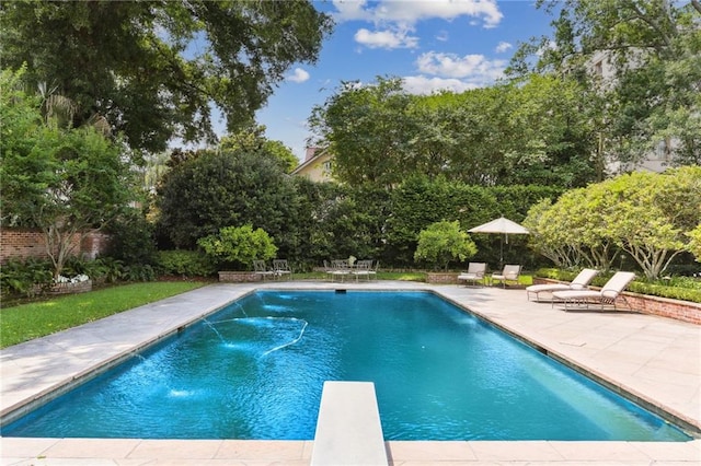 view of pool with pool water feature, a diving board, and a patio