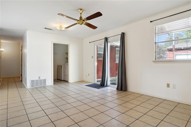 spare room with ceiling fan, washer / dryer, and light tile patterned flooring