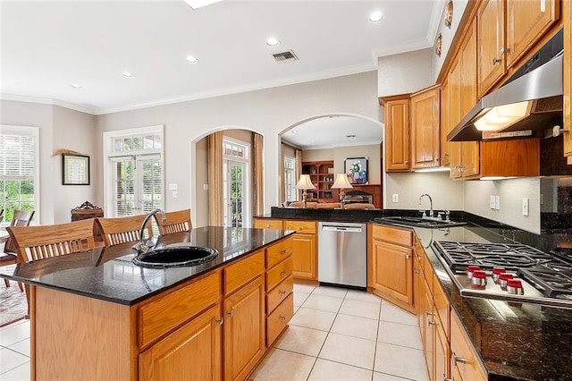 kitchen featuring stainless steel appliances, sink, a center island, and light tile floors