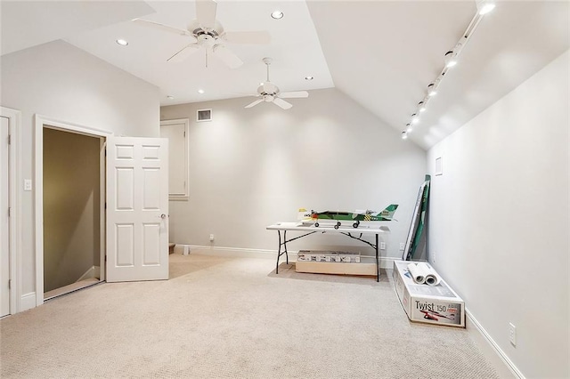 unfurnished bedroom featuring light carpet, vaulted ceiling, and rail lighting