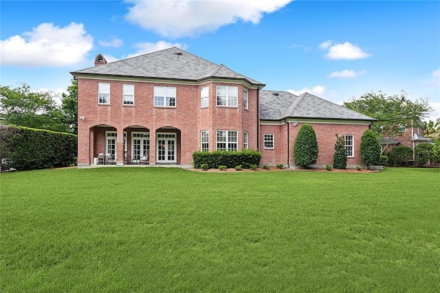 back of property with a patio and a yard