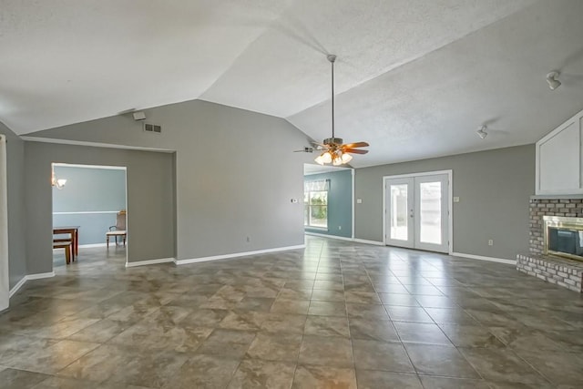 unfurnished living room with tile floors, a brick fireplace, vaulted ceiling, and ceiling fan